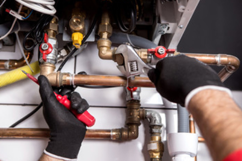 plumber working on copper pipes repair